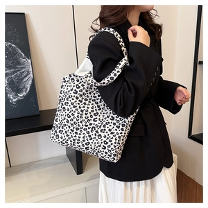 Detailed view of fashionable large leopard print canvas tote bag on female model