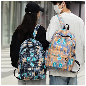 Rear view of couple wearing graffiti print backpacks in black and khaki canvas