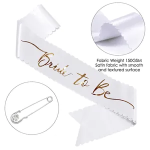 Close-up of Bride to Be white satin sash with gold foil lettering and rhinestone pin