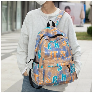 Close-up of graffiti cartoon backpack featuring blue and orange prints on khaki nylon