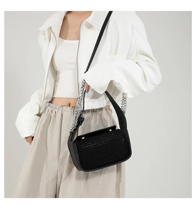 Detail view of black crossbody bag with shiny rhinestones and silver chain strap