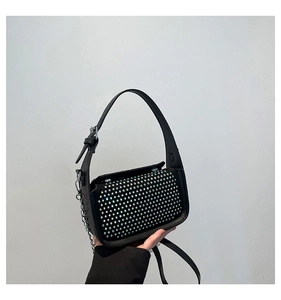 Close-up of black rhinestone mini bag featuring silver metal chain and studded crystals