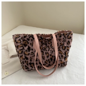 Detail of plush leopard print tote bag with pink leather straps and soft inner lining