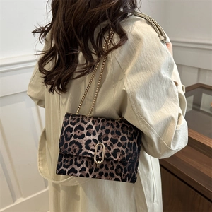 Retro leopard print crossbody bag with gold chain strap shown on a beige coat