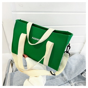 Dettaglio borsa tote in tela verde con tracolla regolabile e scritta FASHIO