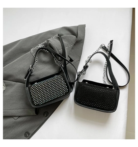 Detail of two black flap crossbody bags featuring colorful rhinestones and studded textures