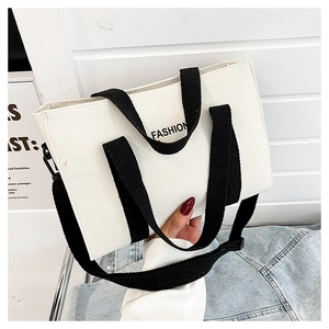 Dettaglio borsa tote in tela con stampa FASHION, manici e tracolla regolabile