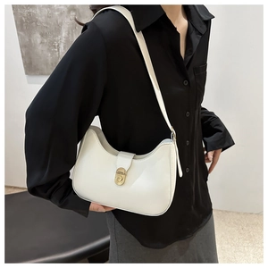Detail of white minimalist hobo bag with vintage gold swivel lock worn by a model