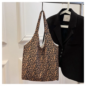 Detail of trendy leopard print canvas tote bag featuring large capacity and dual straps