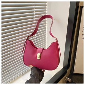 Detail of magenta crescent bag featuring a gold twist lock and adjustable shoulder strap