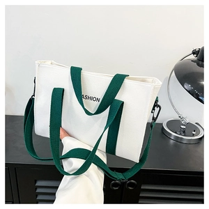 Dettaglio borsa tote in tela bianca con spalline verdi e ganci in metallo nero