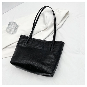 Close-up of black PU leather tote bag featuring embossed star texture and logo detail