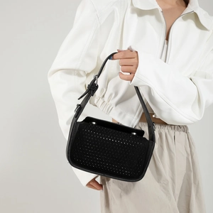 Fashionable black rhinestone shoulder bag with silver buckle held by a model
