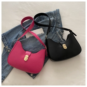 Detail view of stylish fuchsia and black hobo bags with golden metallic twist locks