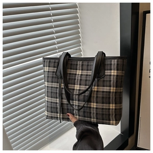 Close-up of a large plaid tote bag with black slim handles for daily commuting style