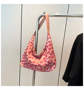Dettaglio della borsa tote leopardata rosa appesa a un appendiabiti in metallo cromato