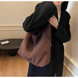 Close-up of deep brown large tote bag in matte suede fabric showing soft drape and capacity