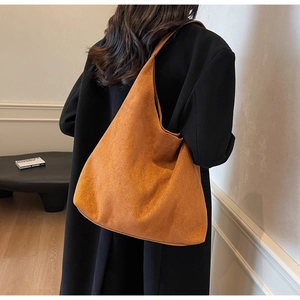 Detailed back view of a large caramel faux suede tote bag worn by a model