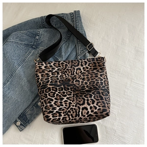 Detail view of leopard print tote bag with black nylon strap and gold hardware accents
