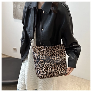 Detailed shot of leopard print tote bag with wide strap on model's shoulder