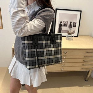 Classic plaid tote bag with leather handles shown in a lifestyle college style setting