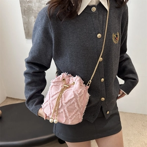 Pink denim bucket bag with frayed quilted texture, gold chain and pearl drawstring charms