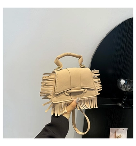 Détail du sac bandoulière beige à franges avec texture daim et design de gland bohème