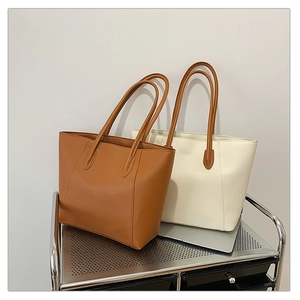 Detail showing high-capacity leather tote bags in brown and beige on a metal storage cart