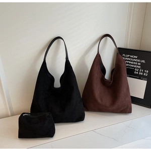 Close-up of suede tote bags in black and dark brown with a matching small zipper pouch