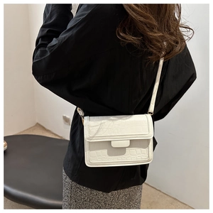 Detail of white crocodile pattern shoulder bag shown from a back crossbody perspective