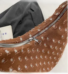 Close-up of smooth silver zipper and distressed brown canvas texture with glitter detail
