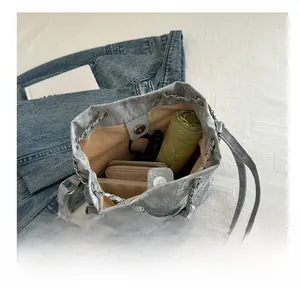 Capacité de rangement du sac seau gris avec parapluie, portefeuille et téléphone inclus