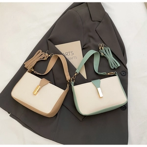 Detail view of two minimalist color-block crossbody bags with sleek gold metal buckles