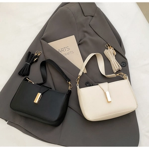 Close-up of minimalist crossbody bags in black and beige with gold metal buckles and matte finish