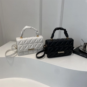 Chic quilted crossbody bag with ruched handle and gold bar detail in black and white