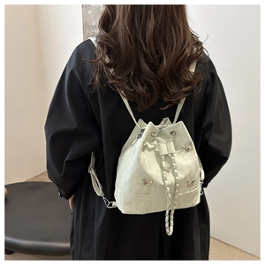 Détail du sac seau vert menthe avec papillons argentés et bandoulière en chaîne