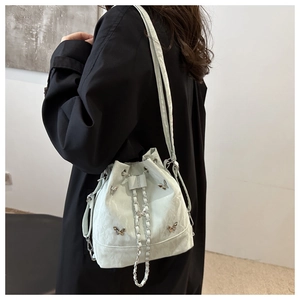 Détail du sac seau vert clair texture marbre avec fermoir papillon argenté et chaîne
