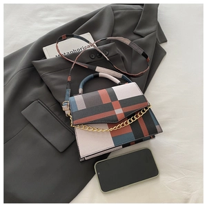 Detailed top view of a color-block patchwork small square bag with chain and strap