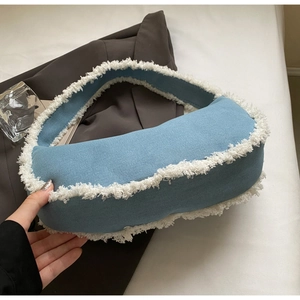 Détail du sac hobo en jean bleu avec bordure à franges blanches et forme de croissant