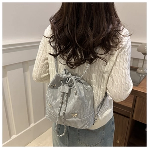 Détail du sac seau argenté avec papillons métalliques et bandoulière en chaîne