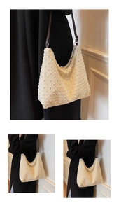 Detailed view of cream textured tote bag with brown leather strap and metal zipper