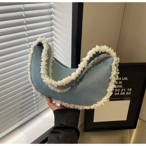 Détail du sac croissant en denim bleu clair avec bordure en molleton blanc