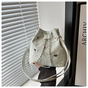 Détail du sac seau en cuir plissé avec papillons en métal argenté et cordon chaîne