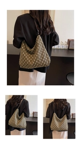 Detail of dark green textured canvas hobo bag with brown leather shoulder strap
