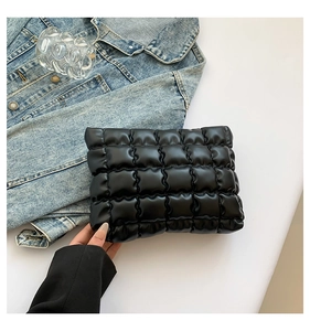 Gros plan de la pochette nuage noire matelassée avec texture bouffante et coutures quadrillées