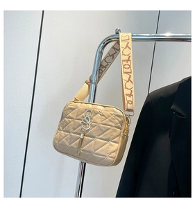 Detail of beige quilted crossbody bag with golden logo and patterned shoulder strap