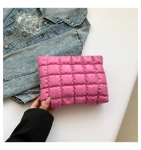 Détail d'une trousse à maquillage matelassée rose avec coutures fines et fermeture éclair