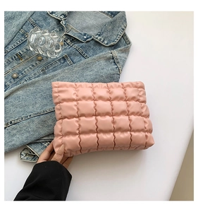 Gros plan d'une trousse à maquillage matelassée rose au design nuage élégant