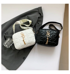 Close-up of quilted leather bags featuring golden SS logos and stylish tassel charms