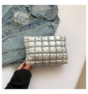 Gros plan d'une pochette en cuir PU matelassé argenté avec un design texturé nuage